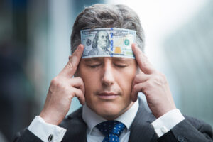 Confident businessman with dollar bill on head